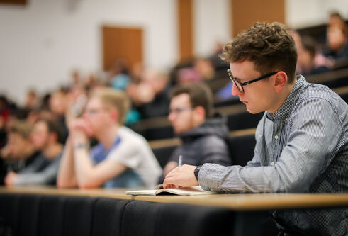 Student taking notes during a lecture