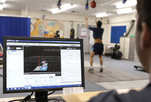 Desktop screen with analysis diagrams. In the background is a person doing exercise. 