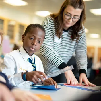 Student helping school pupils