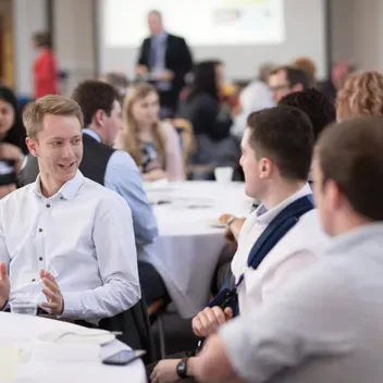 Students sitting discussing ideas at a table as part of an event