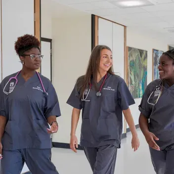 Three medical students wearing scrubs at the University of Dundee School of Medicine