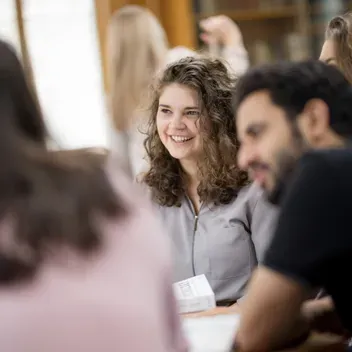 Students sitting smiling and chatting with one another