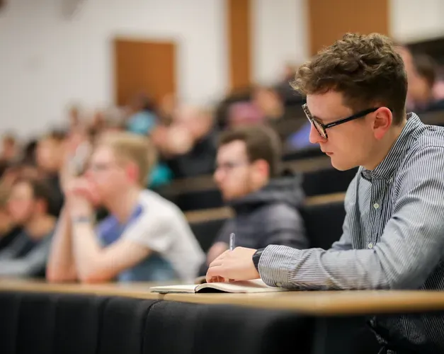 Student taking notes during a lecture
